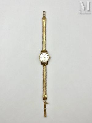 a close up of a gold wrist watch on a white surface