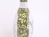 a white vase with a green and yellow design on it