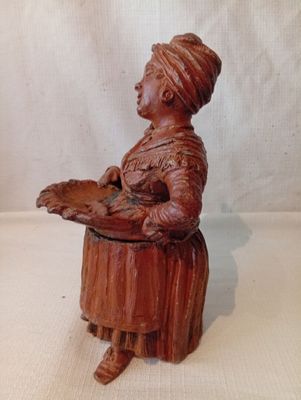 figurine en bois représentant une femme tenant un plateau avec de la nourriture