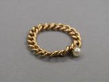 a close up of a gold ring with a pearl on it