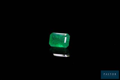 a green emerald stone on a black surface