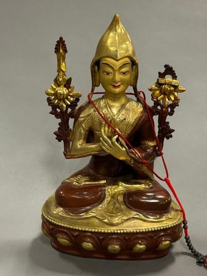 une image représentant une statue de Bouddha avec un cordon rouge