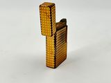a gold lighter that is sitting on a white surface