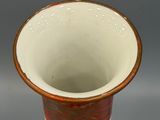 a vase that is sitting on a plate on a table