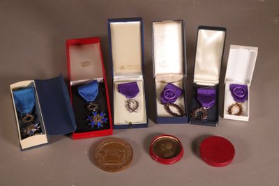 cinq médailles et une médaille dans une boîte posée sur une table
