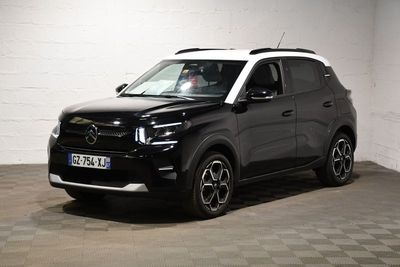 une photo d'une voiture noire et blanche garée dans un garage