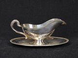 an antique silver plate with a saucer and saucer on a black background