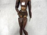 un mannequin en bois posé sur une surface blanche