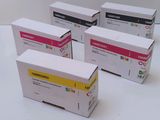 four toner cartridges are sitting in a row on a white surface