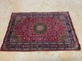 un tapis oriental posé au sol, sur fond rouge