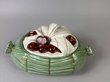 a ceramic bowl with cherries in it on a table