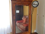 un grand miroir dans un coin de la pièce, à côté d'un canapé