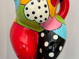 un vase coloré posé sur un socle noir