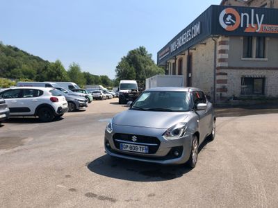 une voiture argentée garée devant un bâtiment dans un parking
