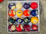 a box full of pool balls with numbers on them