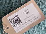 a tag on a sweater that is hanging on a hanger