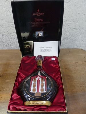 une photo d'un flacon de parfum posé dans une boîte sur une table
