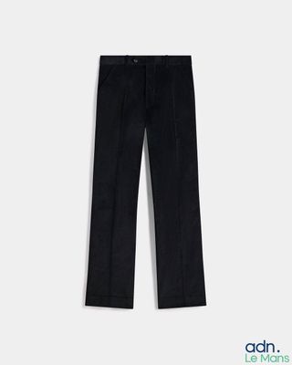 a pair of black pants on a hanger against a white wall