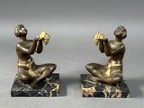 pair of antique bronze figurines of a man and a woman on marble bases