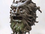 a statue of a man with a beard and a green face