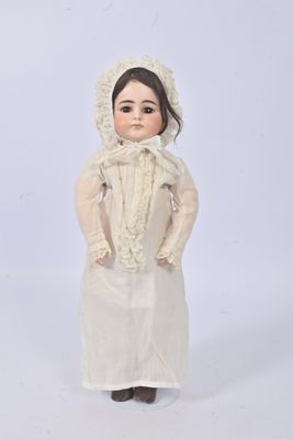 porcelain doll of a woman in a white dress and bonnet