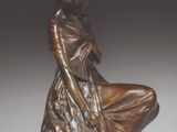 statue en bronze représentant une femme assise sur un rocher, les mains posées sur les genoux