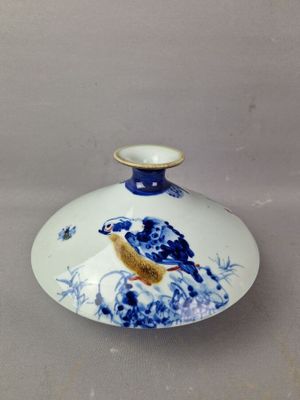 un petit vase bleu et blanc orné d'un oiseau