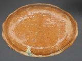 a brown plate with a blue and white design on it