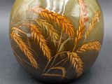 a vase with a painting on it on a table