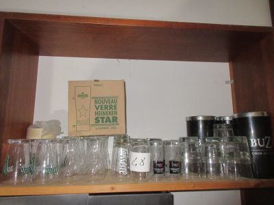 des bouteilles et des verres posés sur une étagère dans une pièce où se trouve une boîte en carton