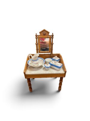 une petite table sur laquelle sont posés un miroir et un service à thé