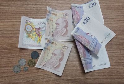 une liasse de billets posée sur une table en bois