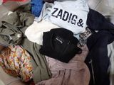 une pile de vêtements posée sur un lit