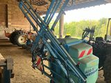 a tractor that is parked in a barn with a crane