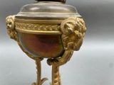 a gold and red vase with a lion head on it