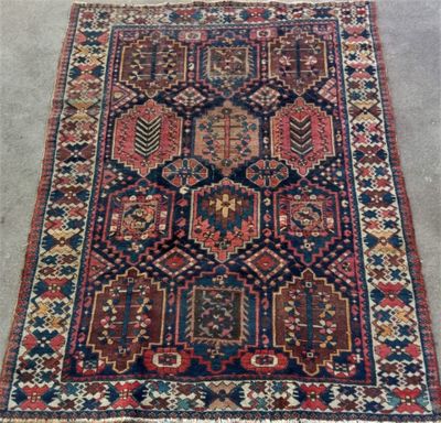 un tapis persan ancien à motifs géométriques sur fond gris