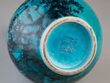 a blue vase with a tree on it sitting on a table