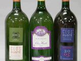 trois bouteilles de vin sont alignées sur une table