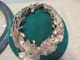 a green hat with a wreath on it next to a mirror