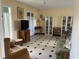 un salon avec un canapé, un fauteuil, une télévision et d'autres meubles
