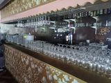 un bar avec de nombreux verres posés dessus et des assiettes sur le comptoir