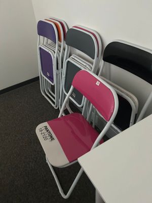 Plusieurs chaises sont alignées contre un mur dans une pièce