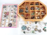 une boîte en bois remplie de bijoux variés, posée sur une surface blanche