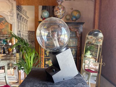 a glass ball sitting on top of a black pedestal