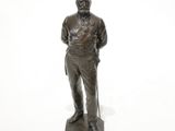 statue of a man with a cane standing on a white surface