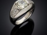 a white gold ring with a cushion cut diamond and pave set diamonds