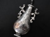 a silver vase that is sitting on a black surface