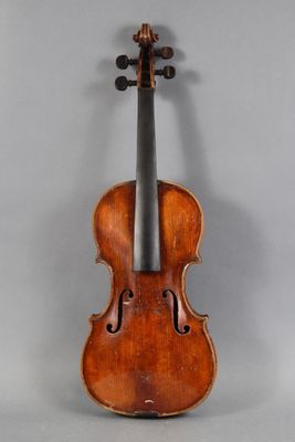 an old violin sitting on top of a table next to a wall