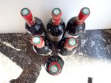 several bottles of wine sitting on top of a counter next to a bottle opener