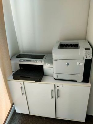 une imprimante posée sur une armoire près d'une fenêtre